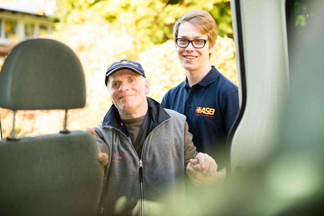 Herr mit ASB-Mitarbeiter steigt in Auto ein